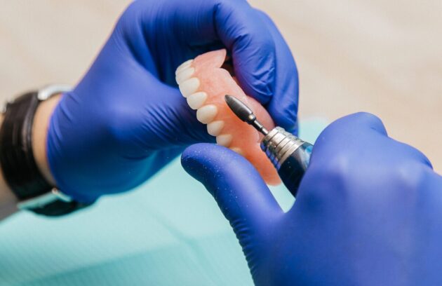 Denturist performing Denture Rebasing with a specialized tool.