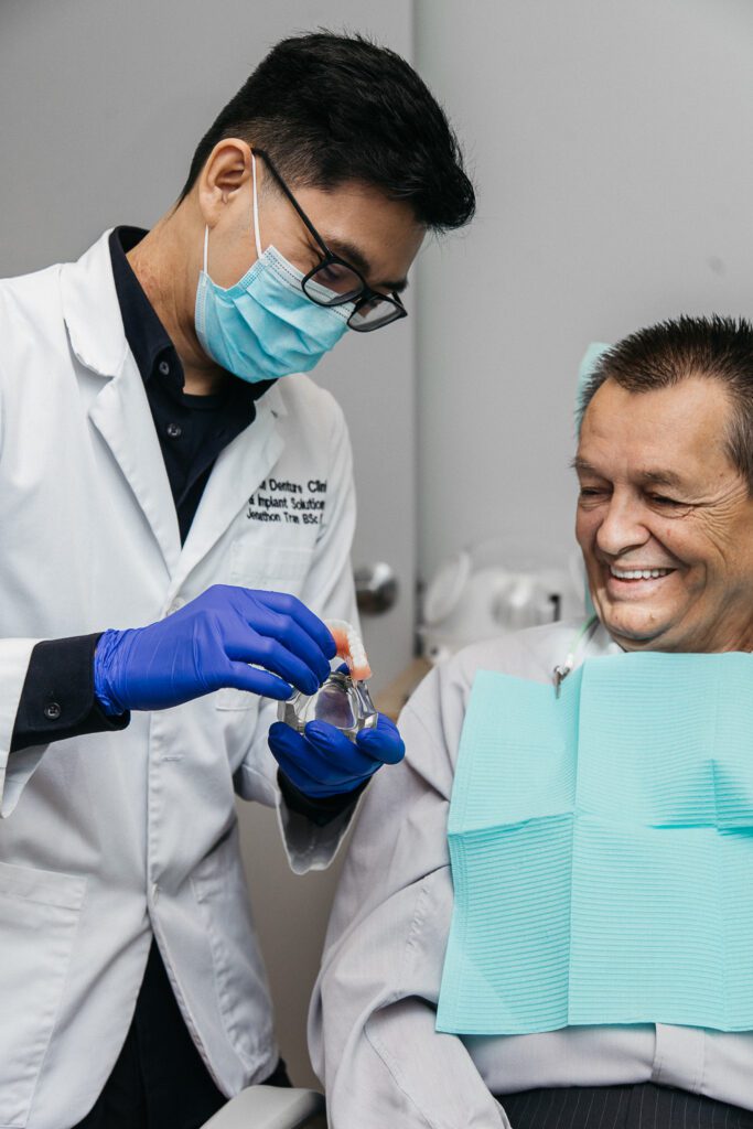 Patient seeing his dentures for the first time as the technician show him.