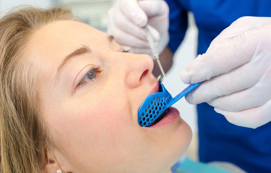 a dentist creating a custom made mouth guard for a patient